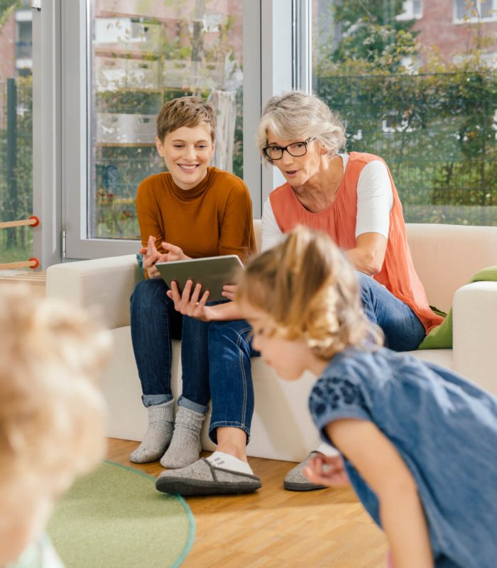 pre-school-teachers-with-tablet-looking-at-children-in-kindergarten.jpg